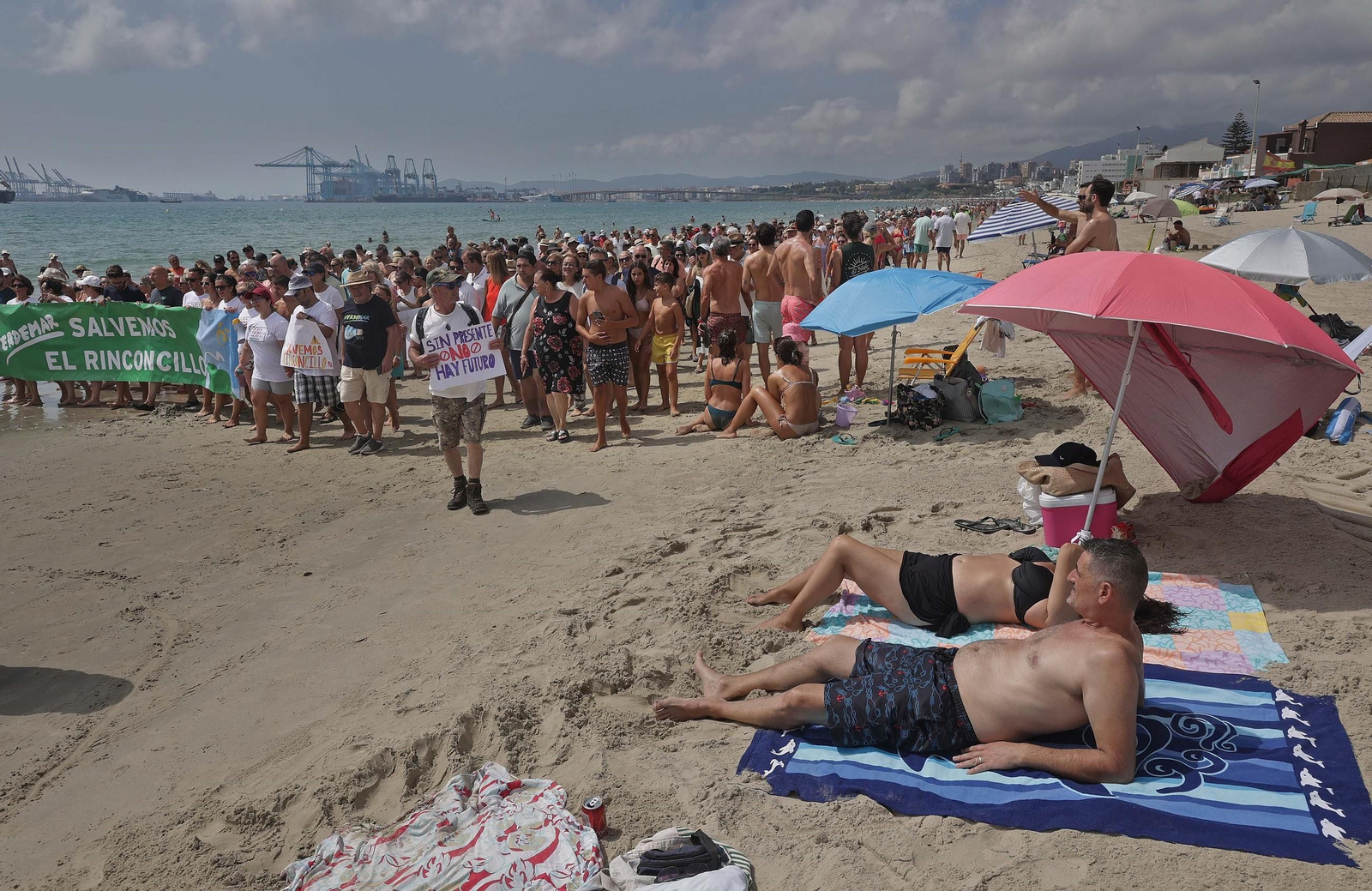 Dos bañistas observan la última manifestación de la plataforma, el pasado agosto.