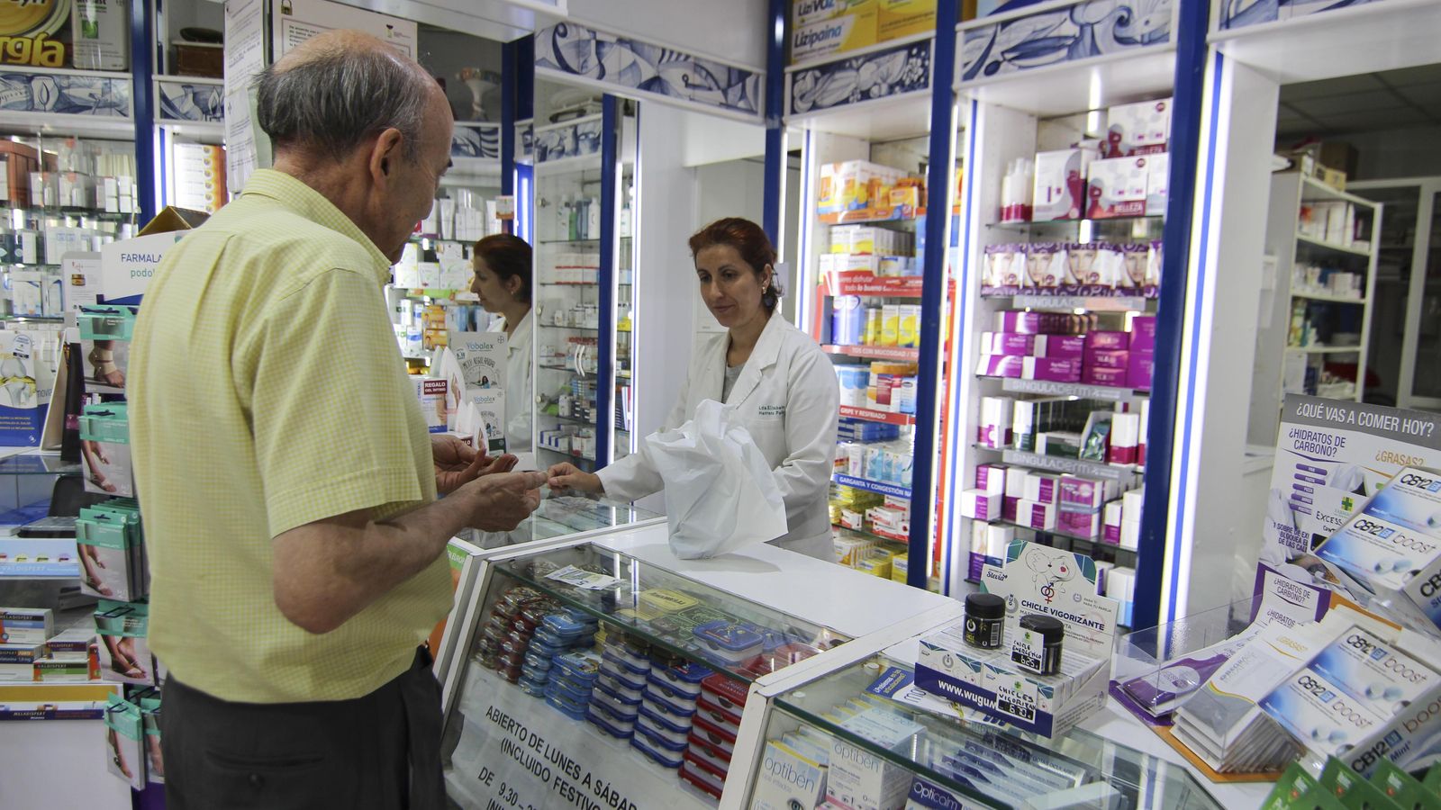 Un hombre compra medicamentos en una farmacia.