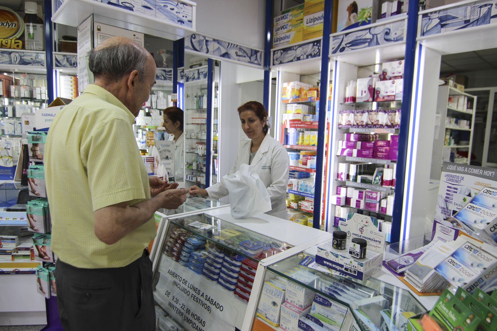 Un hombre compra medicamentos en una farmacia.