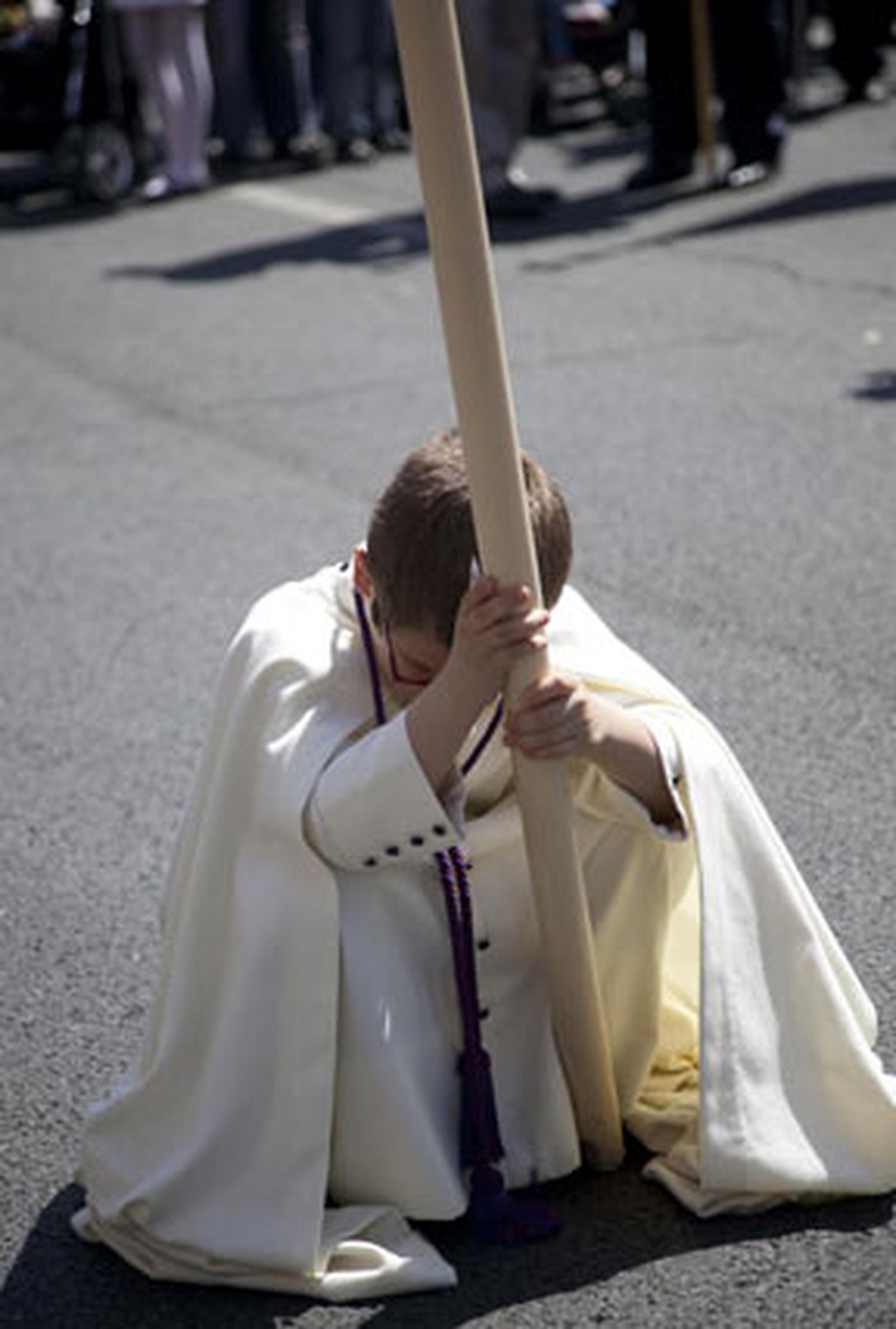 Un menor descansa apoyado en su cirio.

Foto: Jaime Martínez