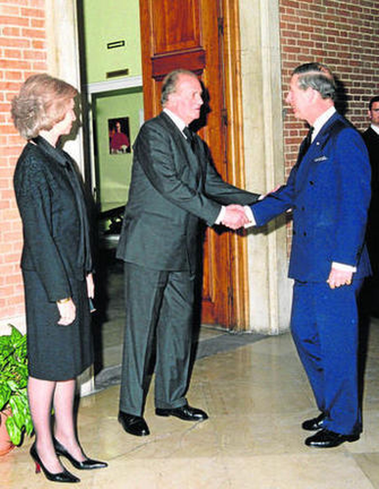 Don Juan Carlos saluda al príncipe Carlos de Inglaterra en presencia de la reina Sofía en 2004.