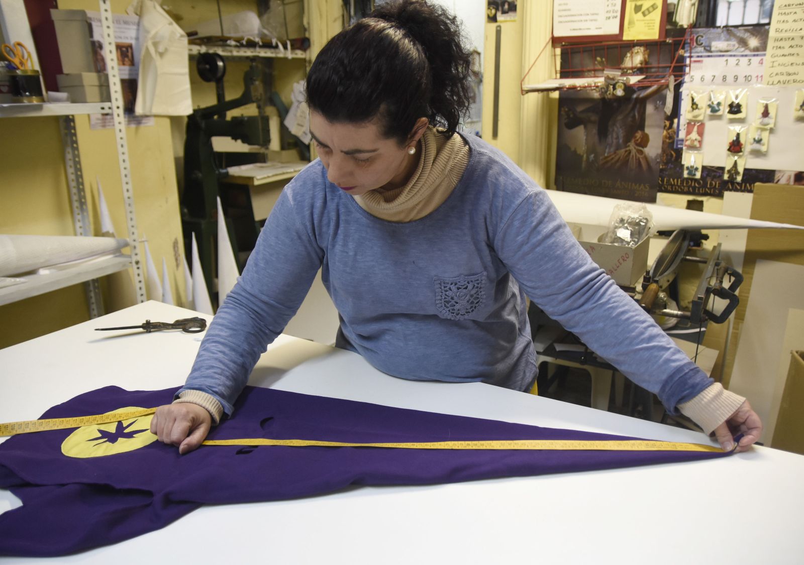 Una mujer confecciona un capirote en una tienda de Córdoba.