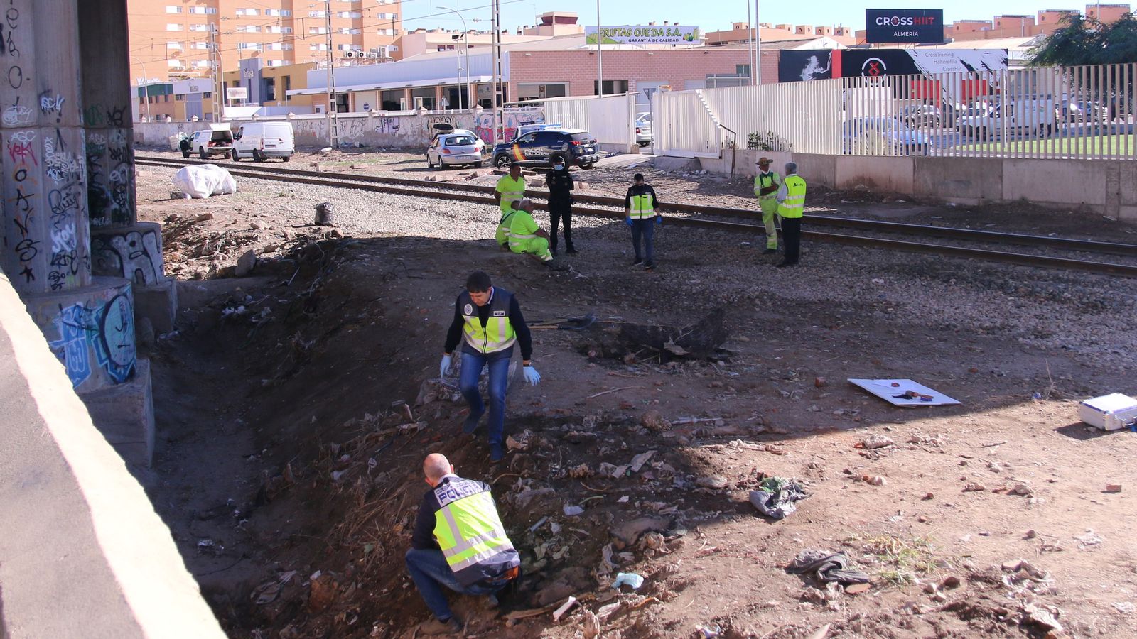 Agentes de la Policía Judicial y de la Policía Científica de la Comisaría de Almería durante la inspección de las vías del tren y del terreno colindante
