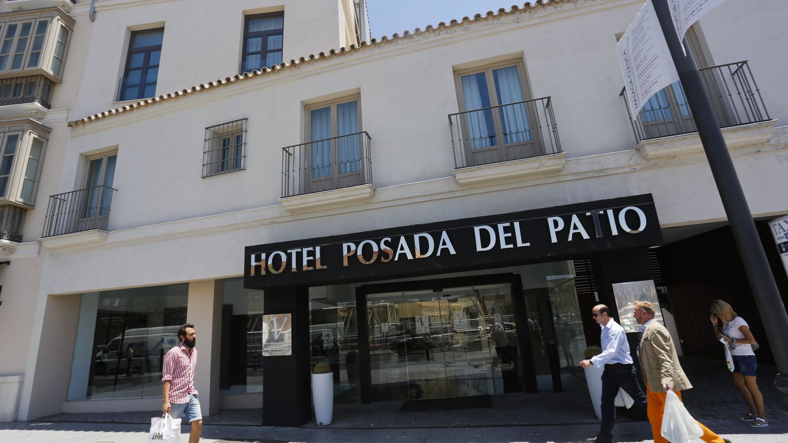 Varias personas pasan por delante de un hotel en Málaga capital.