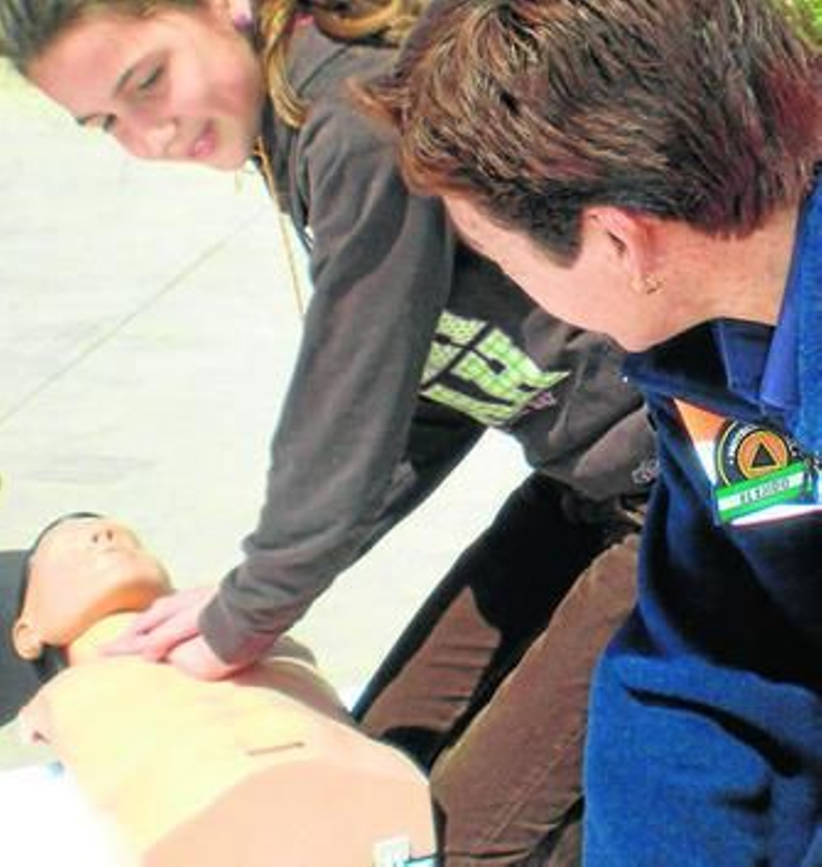 Un operario de Protección Civil muestra a una alumna cómo realizar la reanimación en un muñeco.