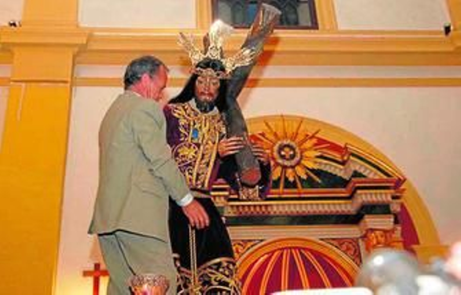Momento en el que es colocada la insignia de oro de la hermandad de la Pastora a Jesús Nazareno.