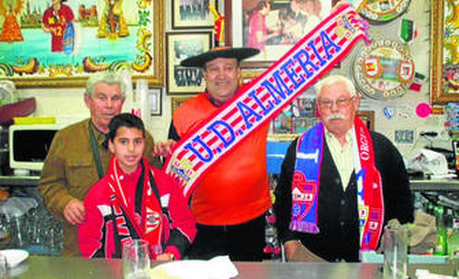 Tres aficionados almerienses se inmortalizaron junto a Manolo tras la barra de 'Tu Museo Deportivo'.