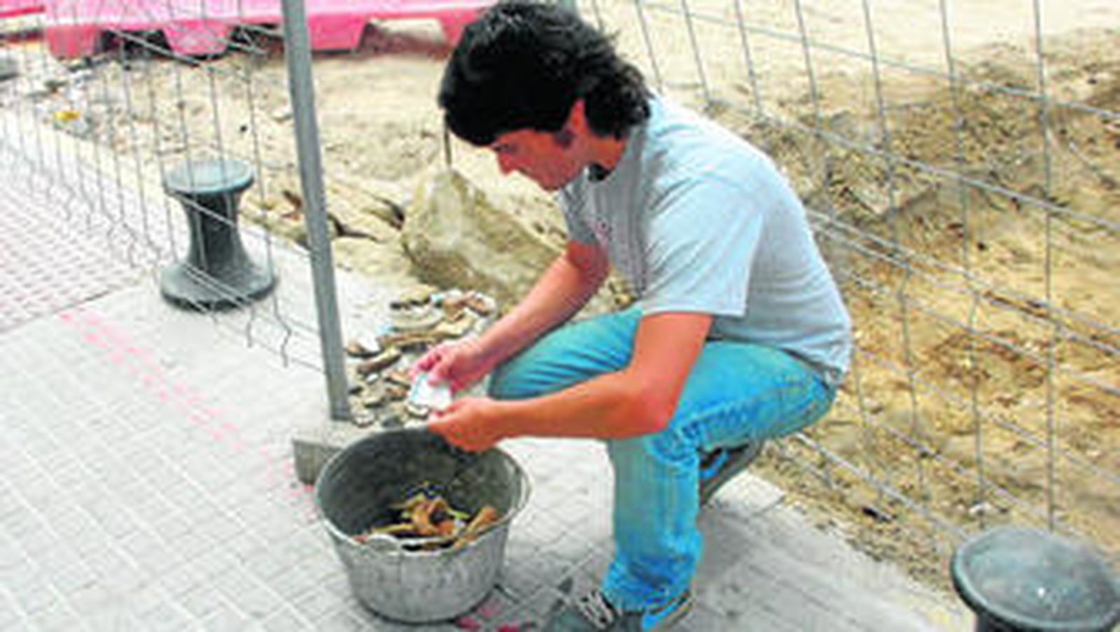 El arqueólogo José Manuel Lojo analiza los restos de cerámica antigua aparecidos en el tramo de la calle Palacios donde hay actualmente movimientos de tierra.