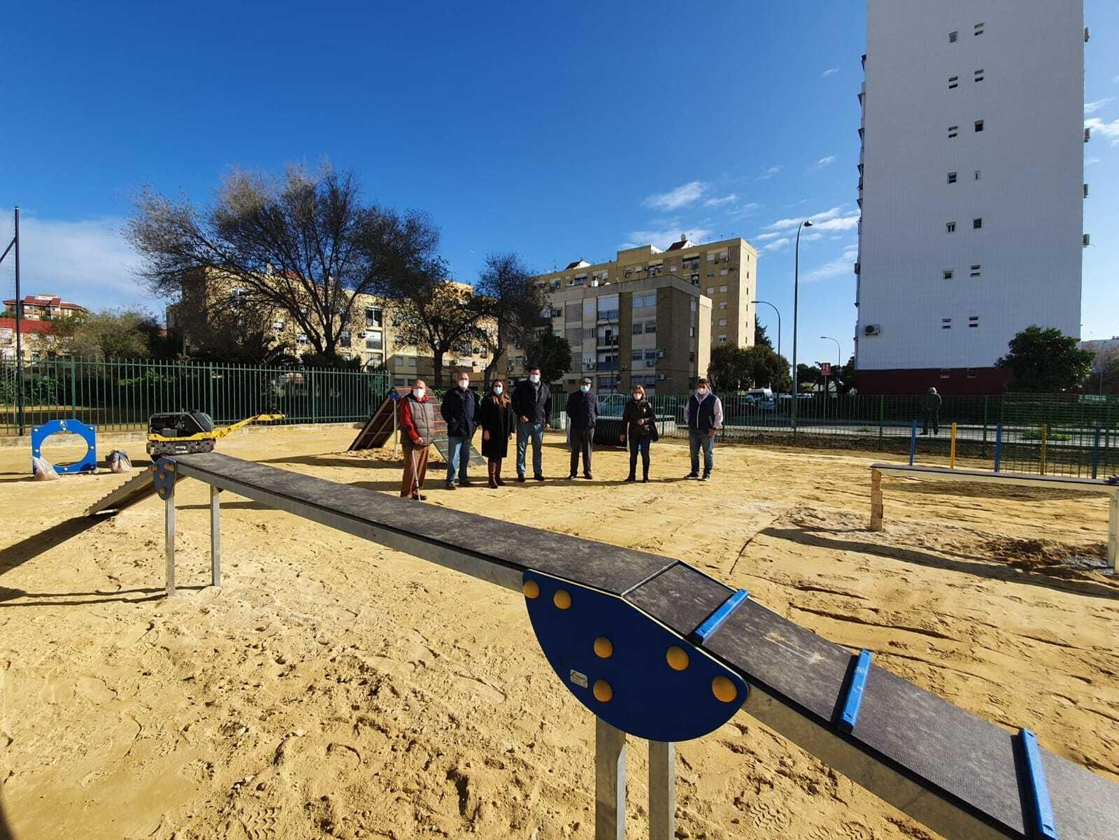 Una imagen del nuevo espacio canino en La Oliva y, al fondo, la responsable del Distrito Sur con vecinos de la zona.