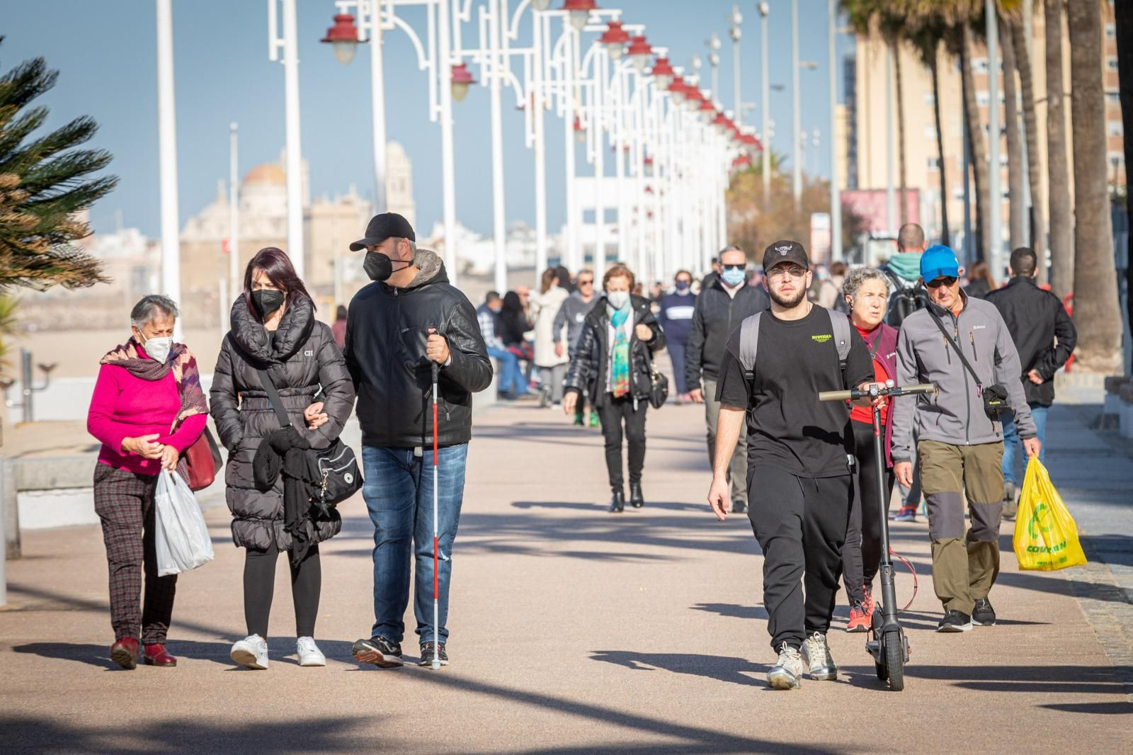Gente paseando por el paseo marítimo de Cádiz.