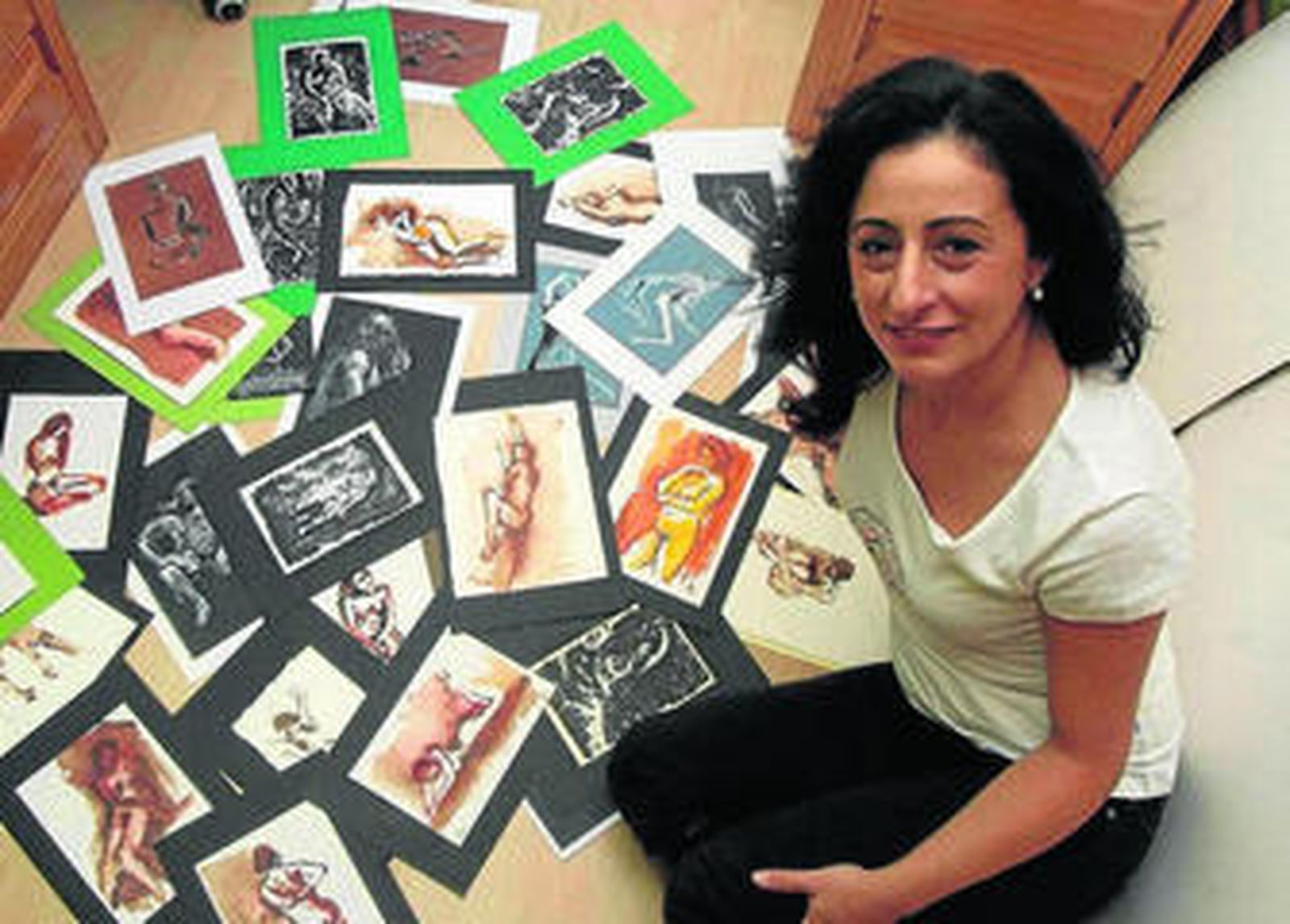 La artista Gabriela Berlingeri rodeada con sus bocetos de desnudos hechos con modelos en vivo.