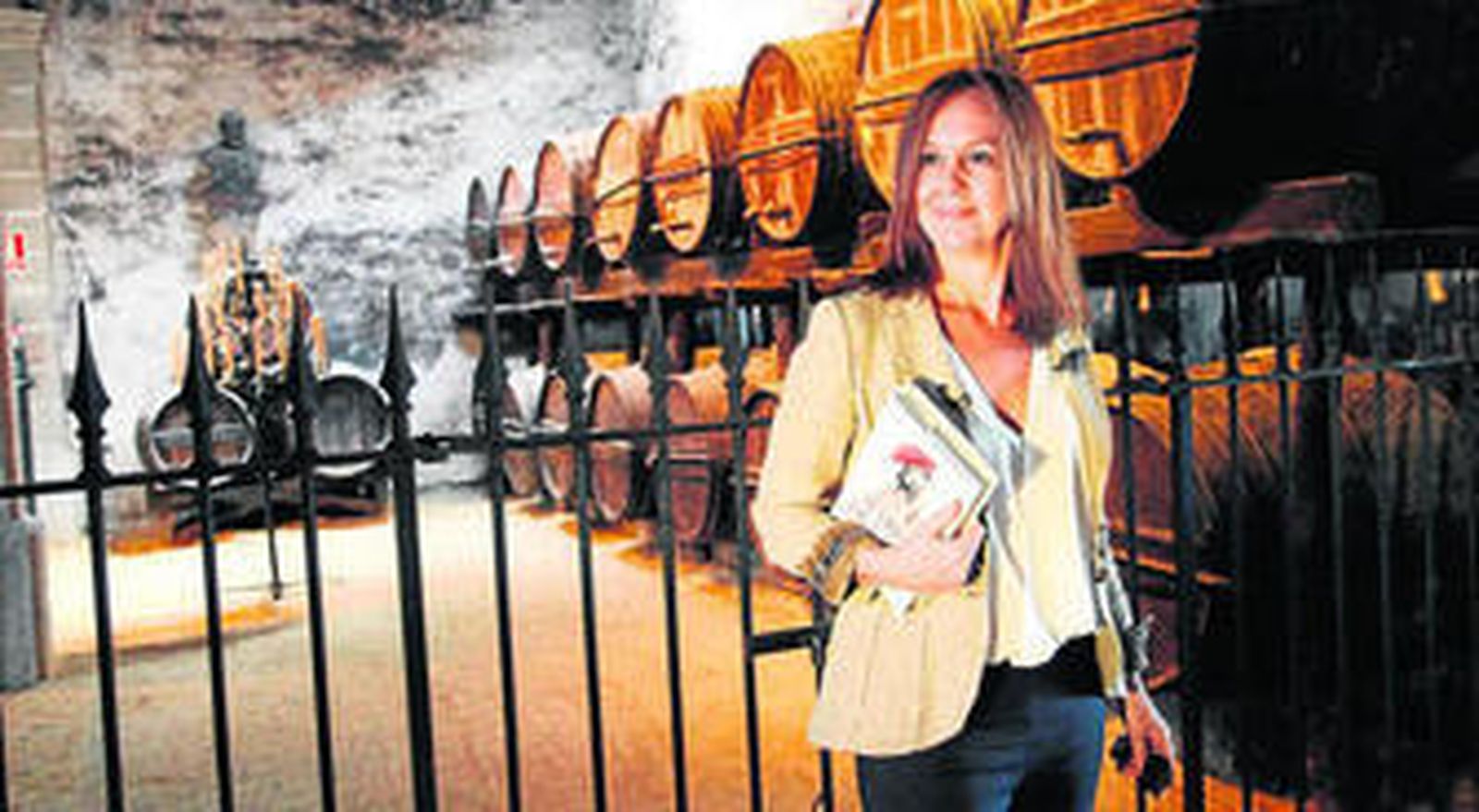 María Dueñas, libro en mano, posa en la bodega jerezana Los Apóstoles de González Byass antes de la entrevista.