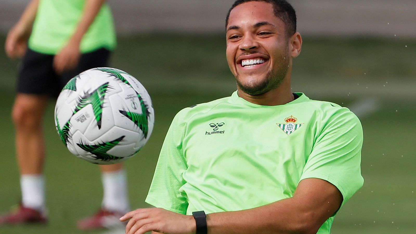 Vitor Roque sonríe mientras juega con un balón de la Conference en un entrenamiento en la ciudad deportiva del conjunto verdiblanco.