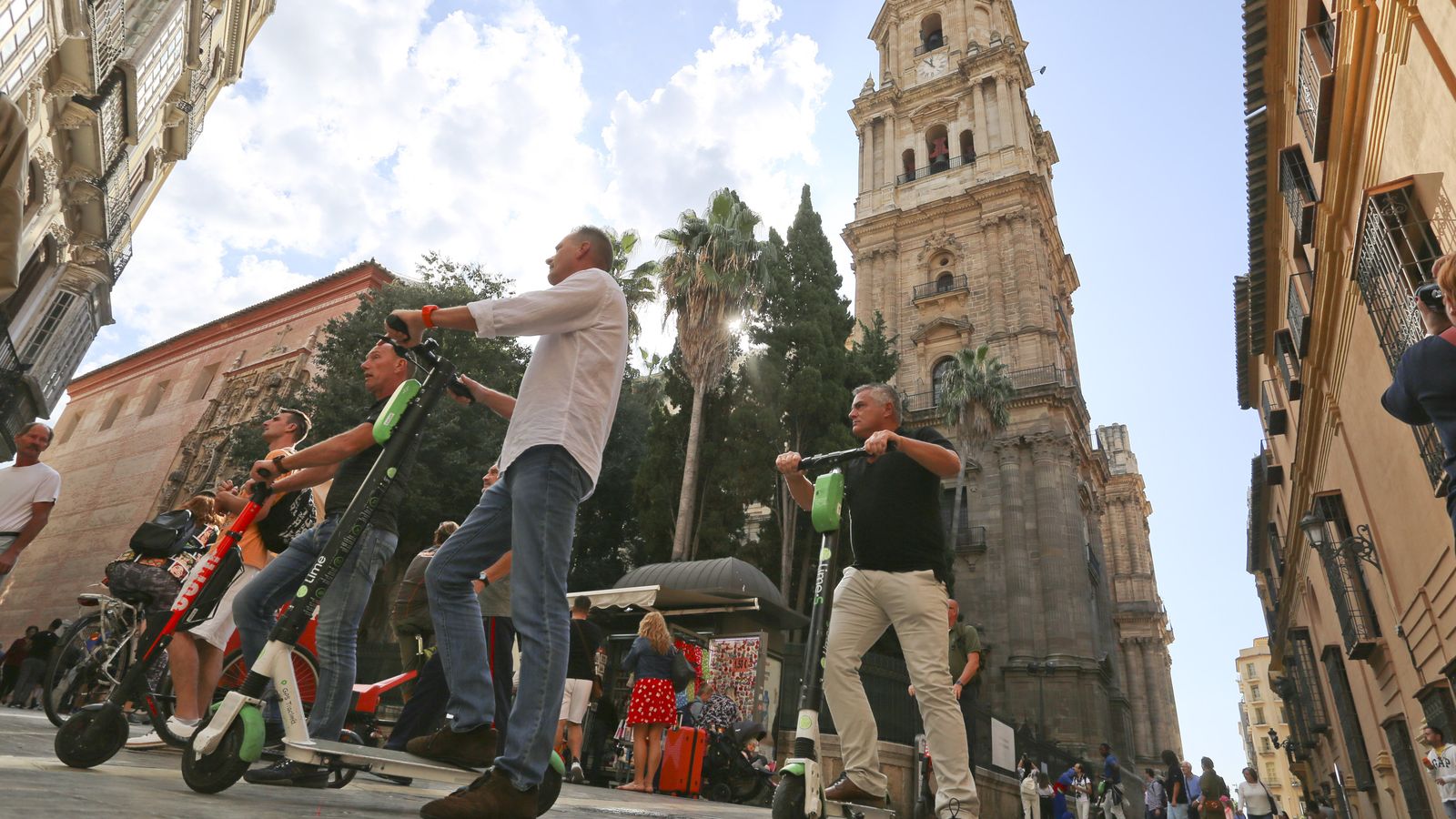 Un grupo de usuarios de patinetes eléctricos circula por las proximidades de la Catedral de Málaga.
