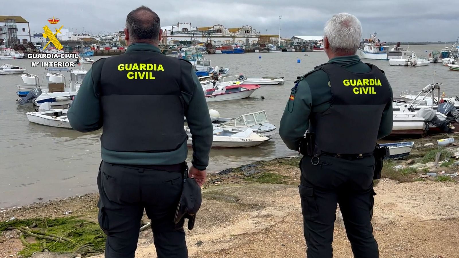 Dos agentes, en la ría del Carreras, en Isla Cristina (Huelva).