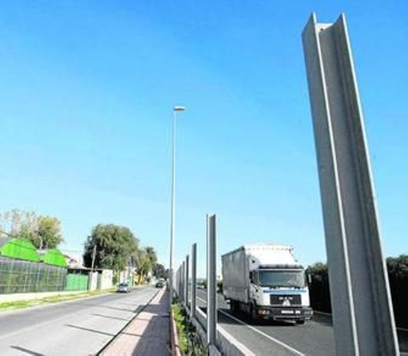 Vista general de la vía de servicio de la A-7 a su paso por Los Cortijillos, la autovía y los postes sin retirar.