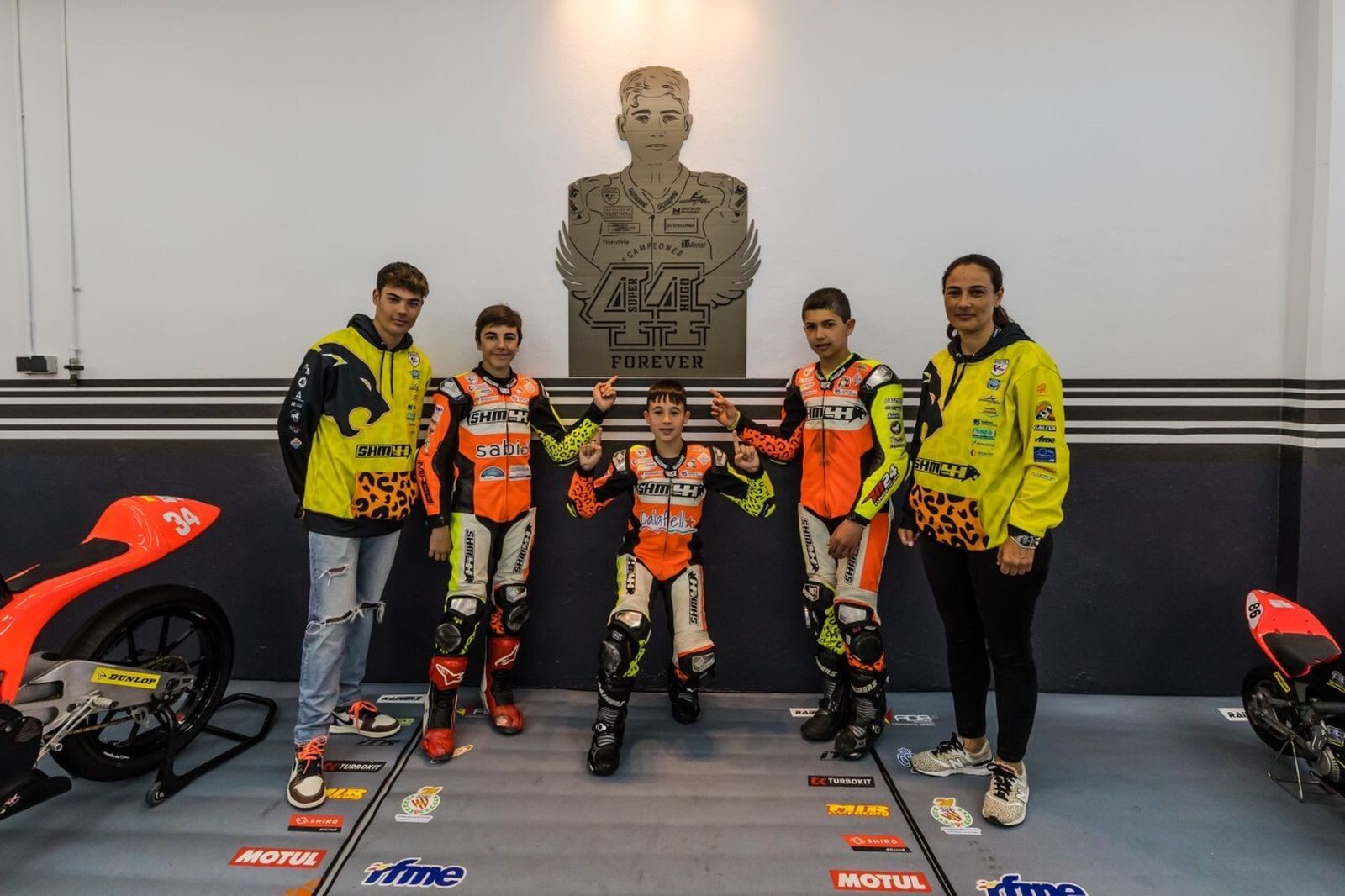 Los tres pilotos del equipo SHM44, con el hermano y la madre de Hugo Millán.