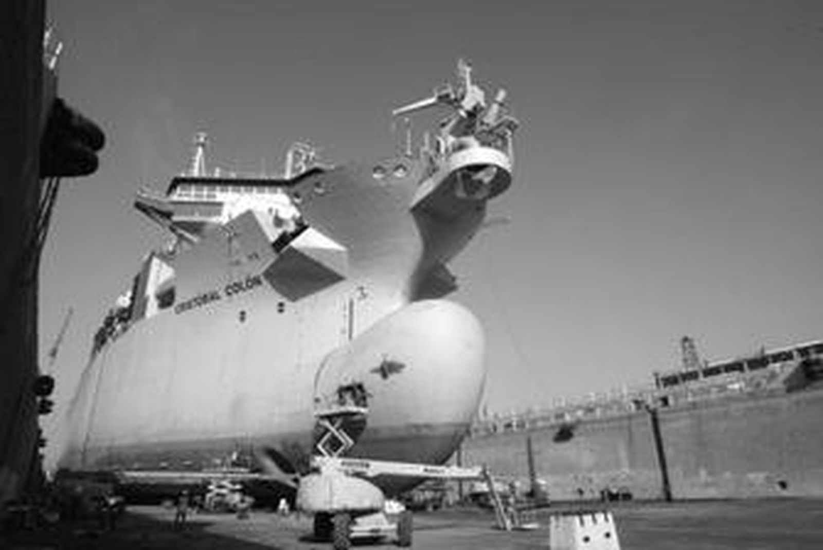 El buque draga de succión en el interior del dique seco de Cernaval, donde maquinaria y trabajadores realizan reparaciones en su exterior.