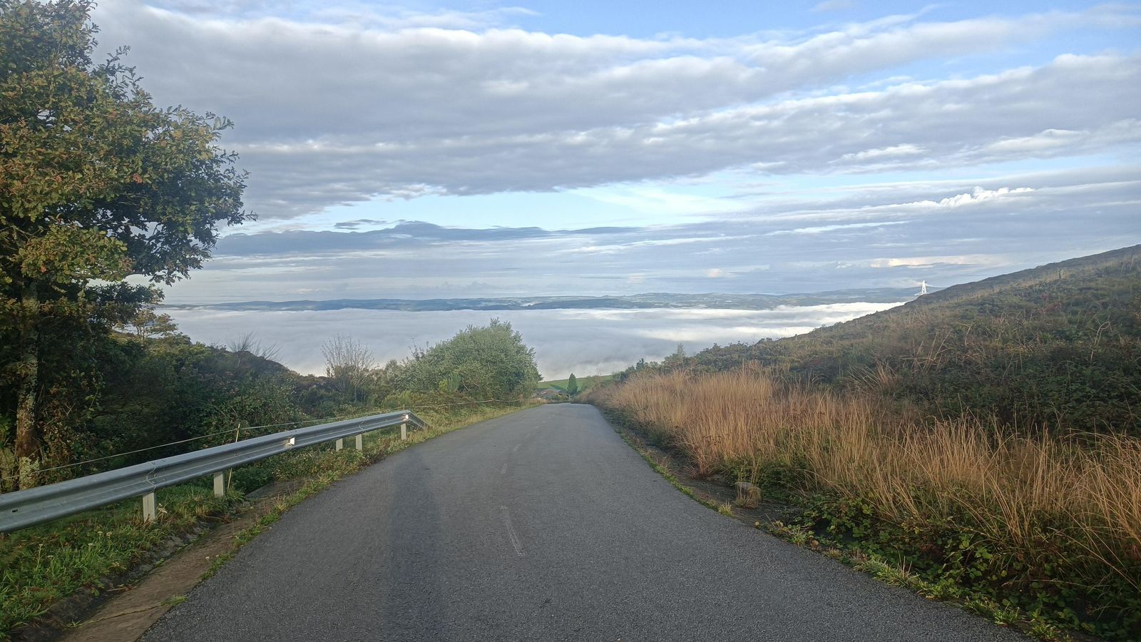 Un carril asfaltado sube una cuesta tras pasar La Mesa.