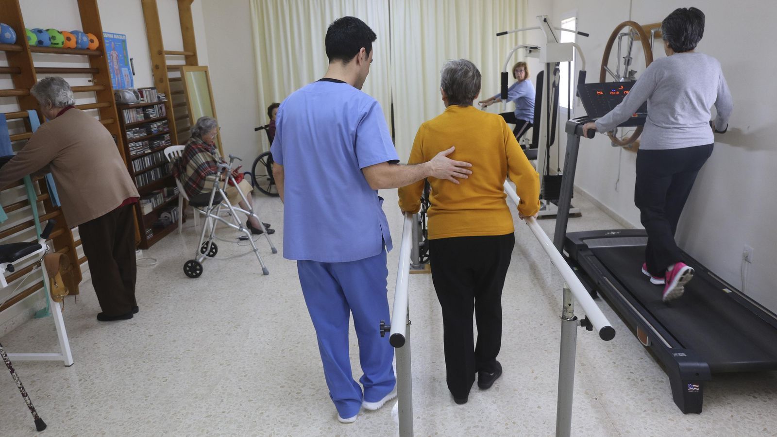 Varias personas hacen rehabilitación en la sala de fisioterapia.