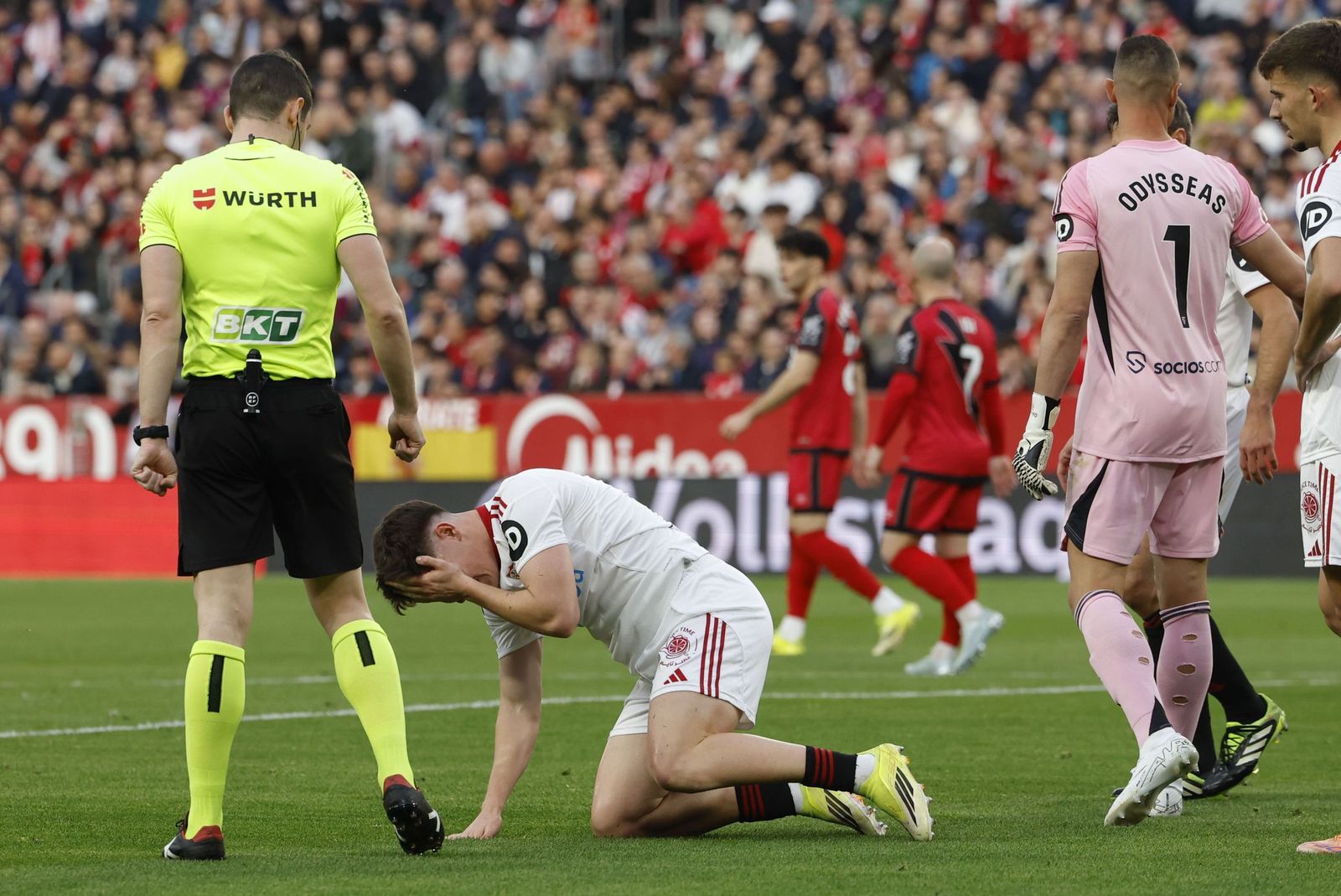 Oso se duele en el césped y Vlachodimos coversa con sus defensas.