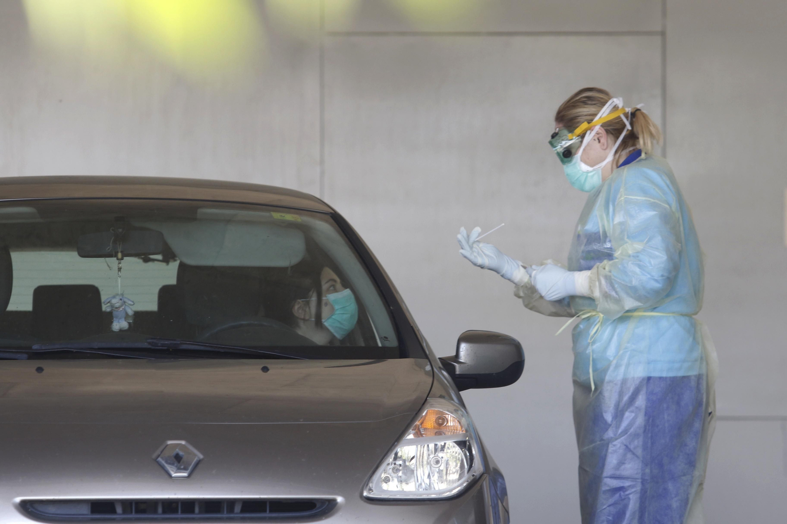 Una profesional recoge muestras desde los coches en el Castilla del Pino.
