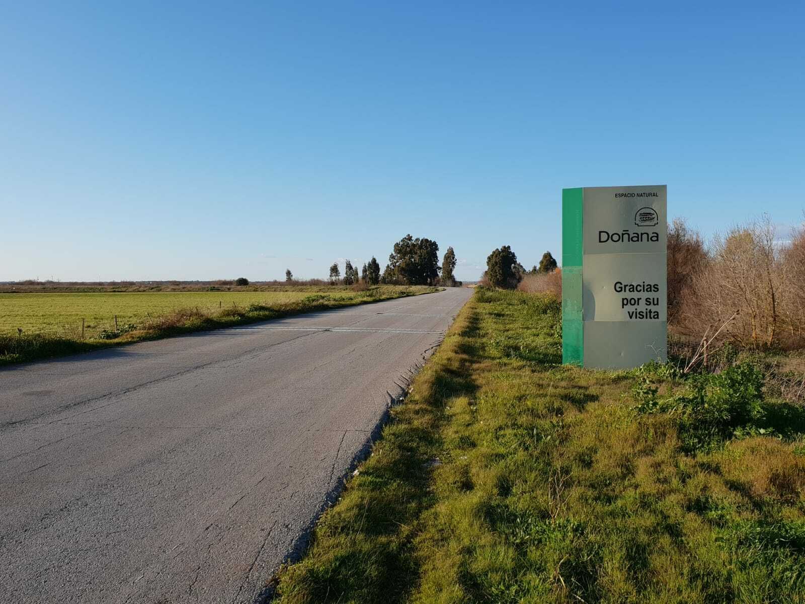 Una imagen facilitada por WWF del camino asfaltado, junto al cartel de Doñana.