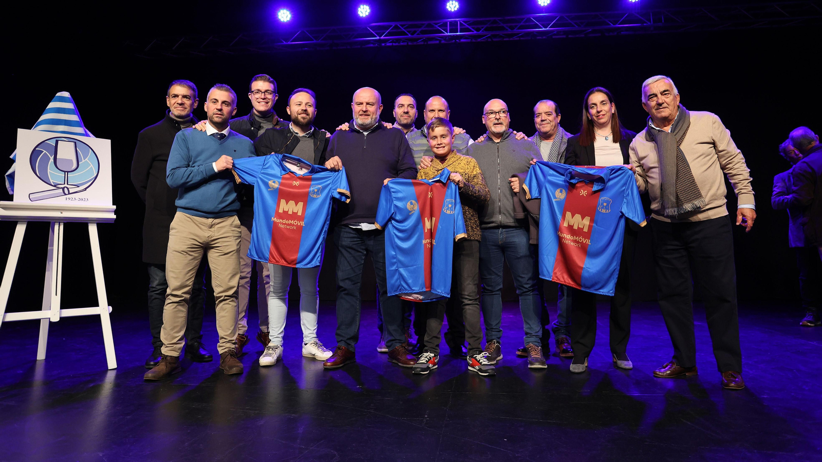 Directivos y colaboradores del Jerez Industrial posan junto al logo del 'Origen Centenario' y una camiseta azulgrana conmemorativa. Directivos y colaboradores del Jerez Industrial posan junto al logo del 'Origen Centenario' y una camiseta azulgrana conmemorativa.