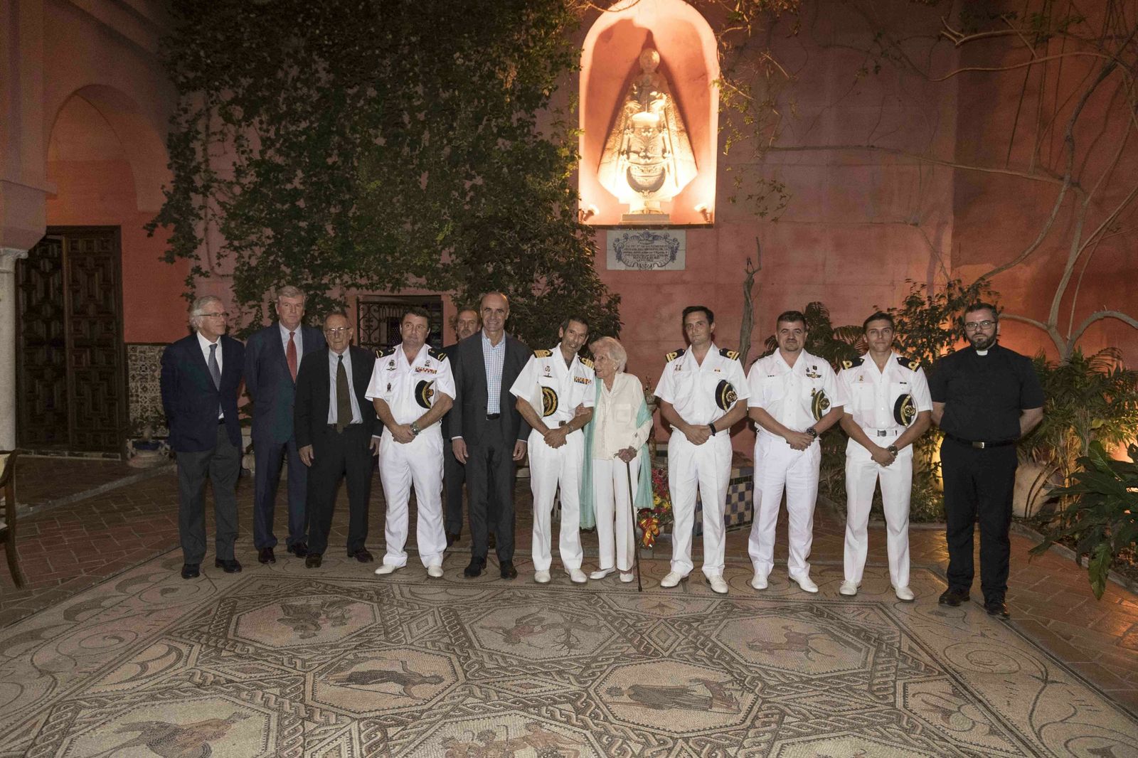 Los cinco marinos del buque-escuela Juan Sebastián de Elcano y el capellán con María Asunción Milá, cuatro de sus hijos y el delegado de Cultura, ante la Virgen de los Remedios.