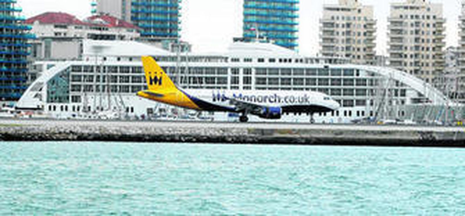 Un avión despega del aerpuerto de Gibraltar ante el barco hotel 'Sunborn', atracado en Ocean Village.