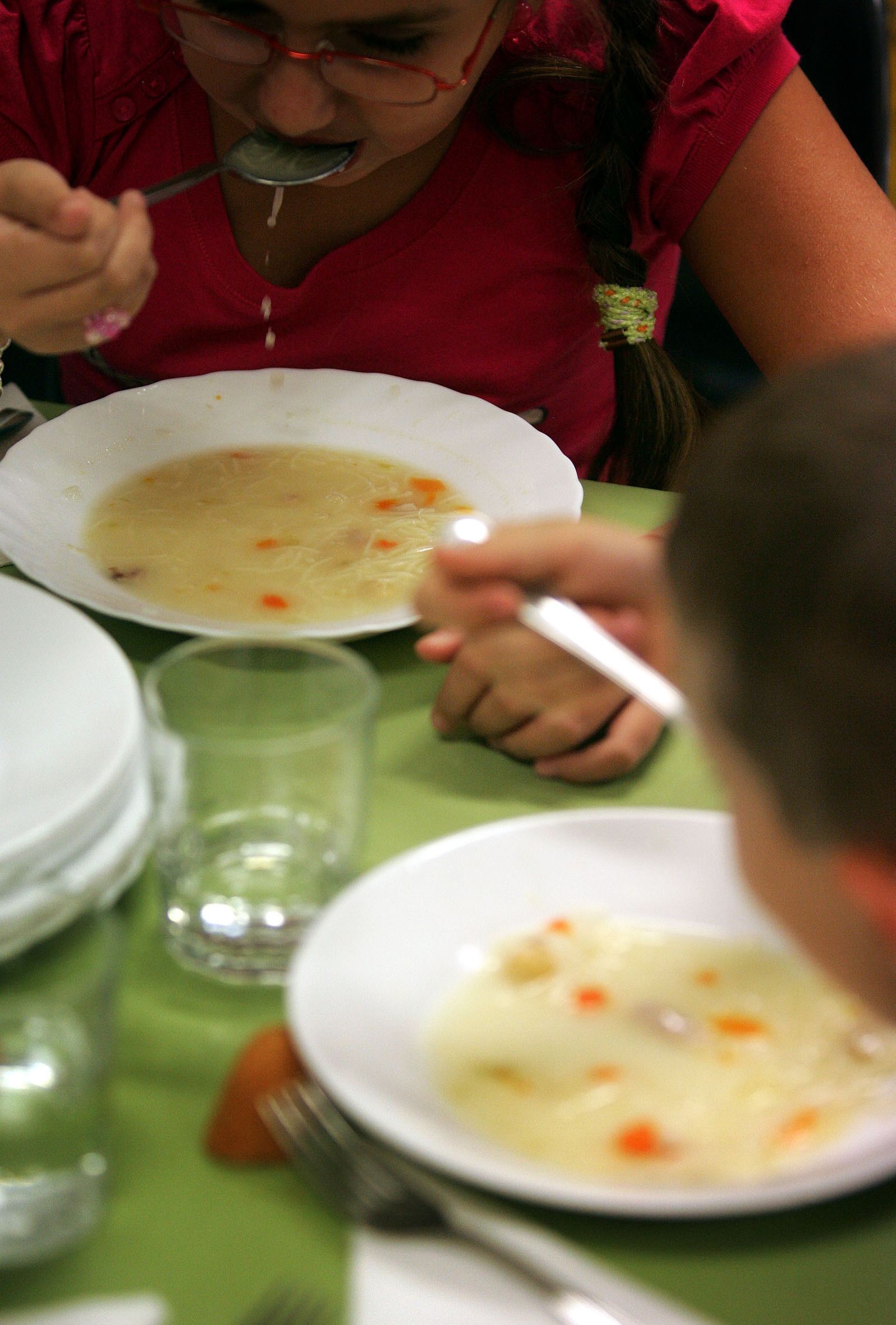 Niños comiendo en el comedor escolar.