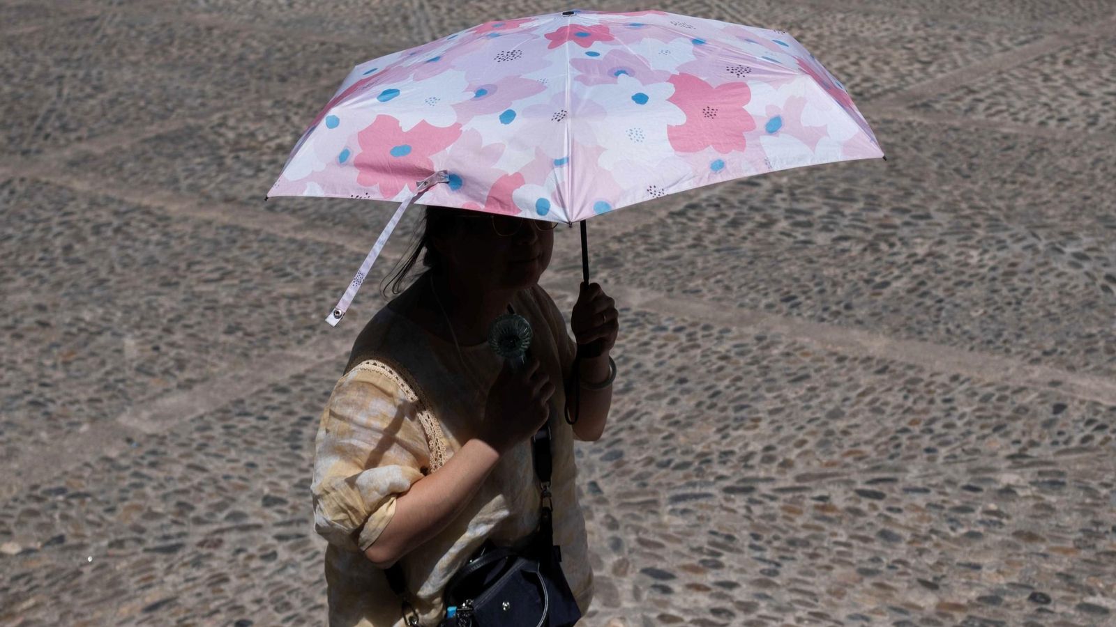 Una turista en Ronda, con sombrilla para protegerse del sol, y un ventilador de mano. Una turista en Ronda, con sombrilla para protegerse del sol, y un ventilador de mano.