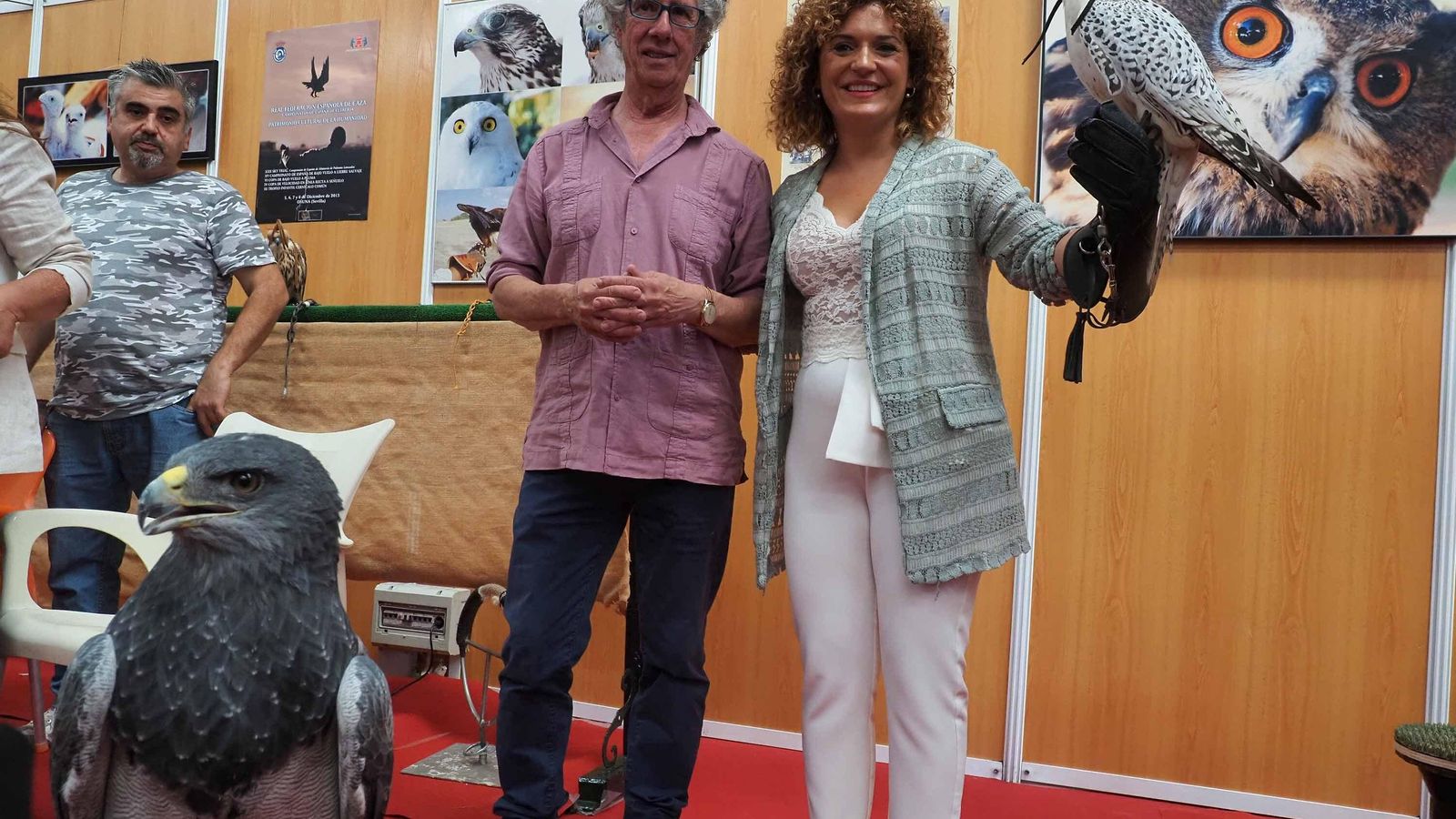 La presidenta de la Diputación de Huelva, Mª Eugenia Limón, sostiene una rapaz en el expositor del cetrero Manuel Diego Pareja-Obregón