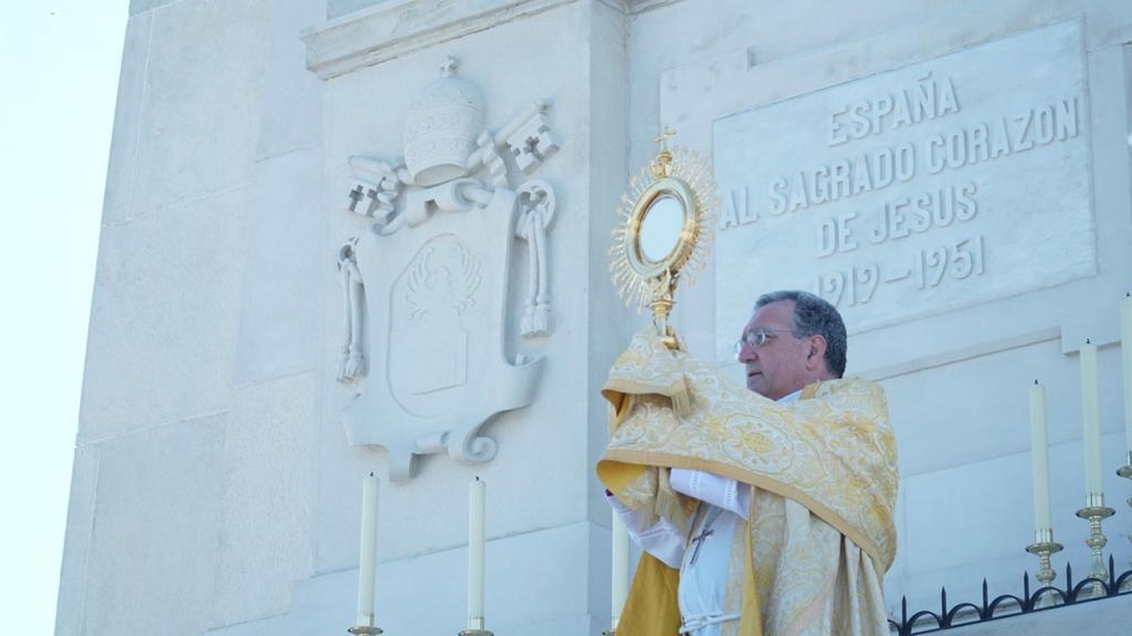 Ginés levanta el Santísimo ante el monumento al Sagrado Corazón de Jesús.