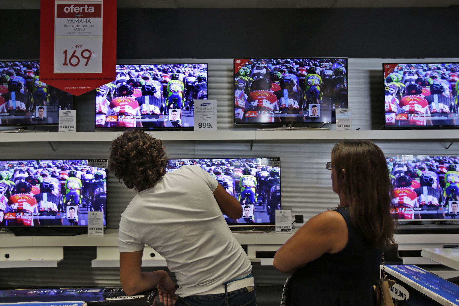 Una pareja en una tienda de televisores.