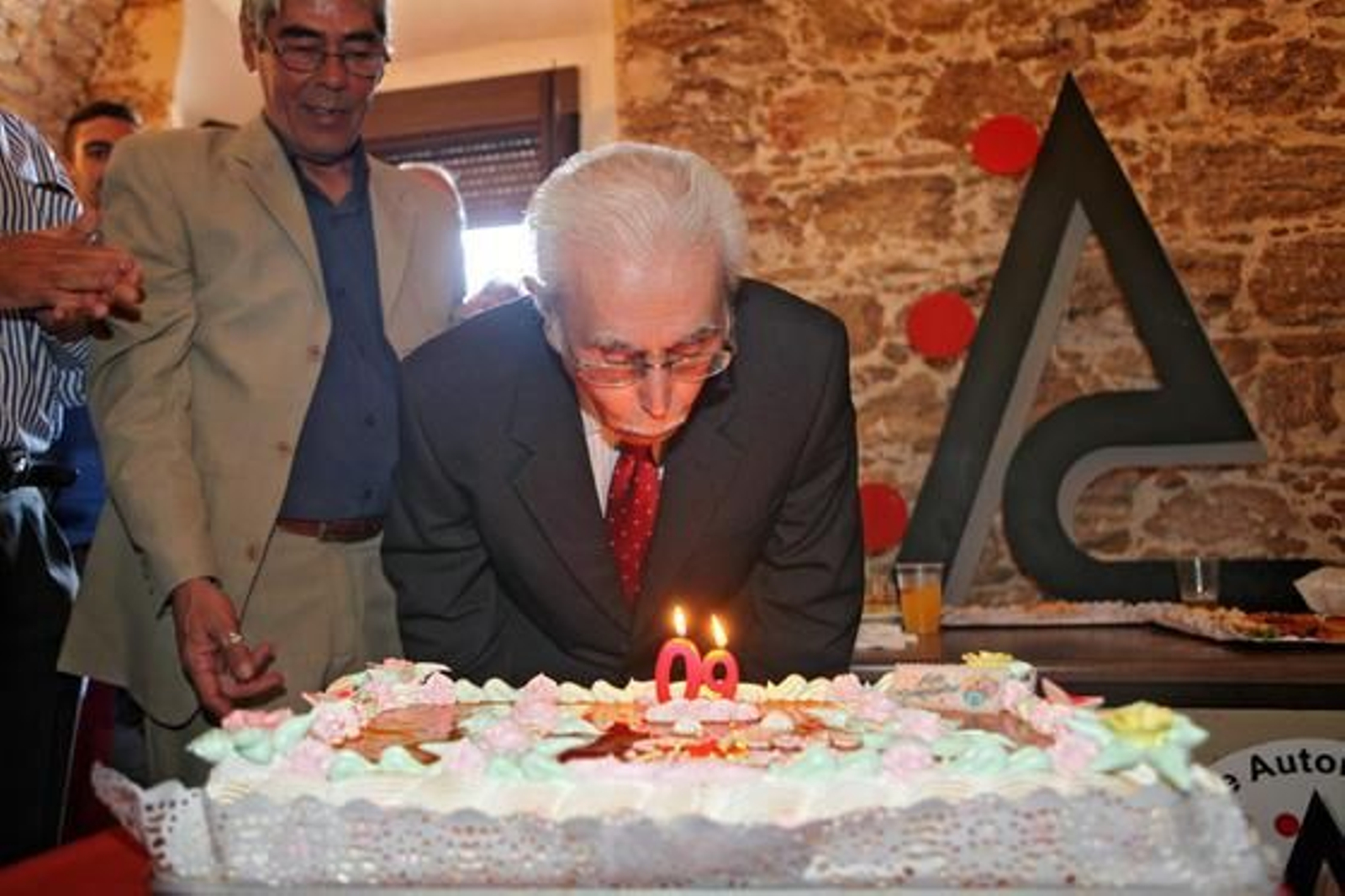 Enrique  Villegas  sopla las velas de la tarta por su 90 cumpleaños en la sede de la Asociación de Autores./Jesús Marín