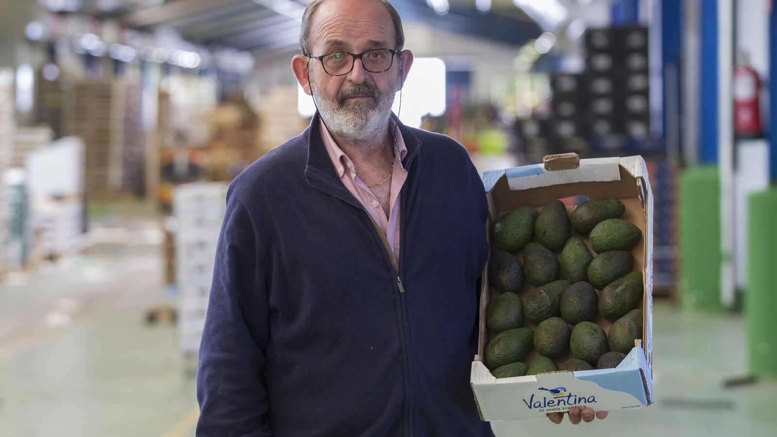 Pepe del Cid posa con una caja de aguacates junto a su puesto en Mercamálaga.