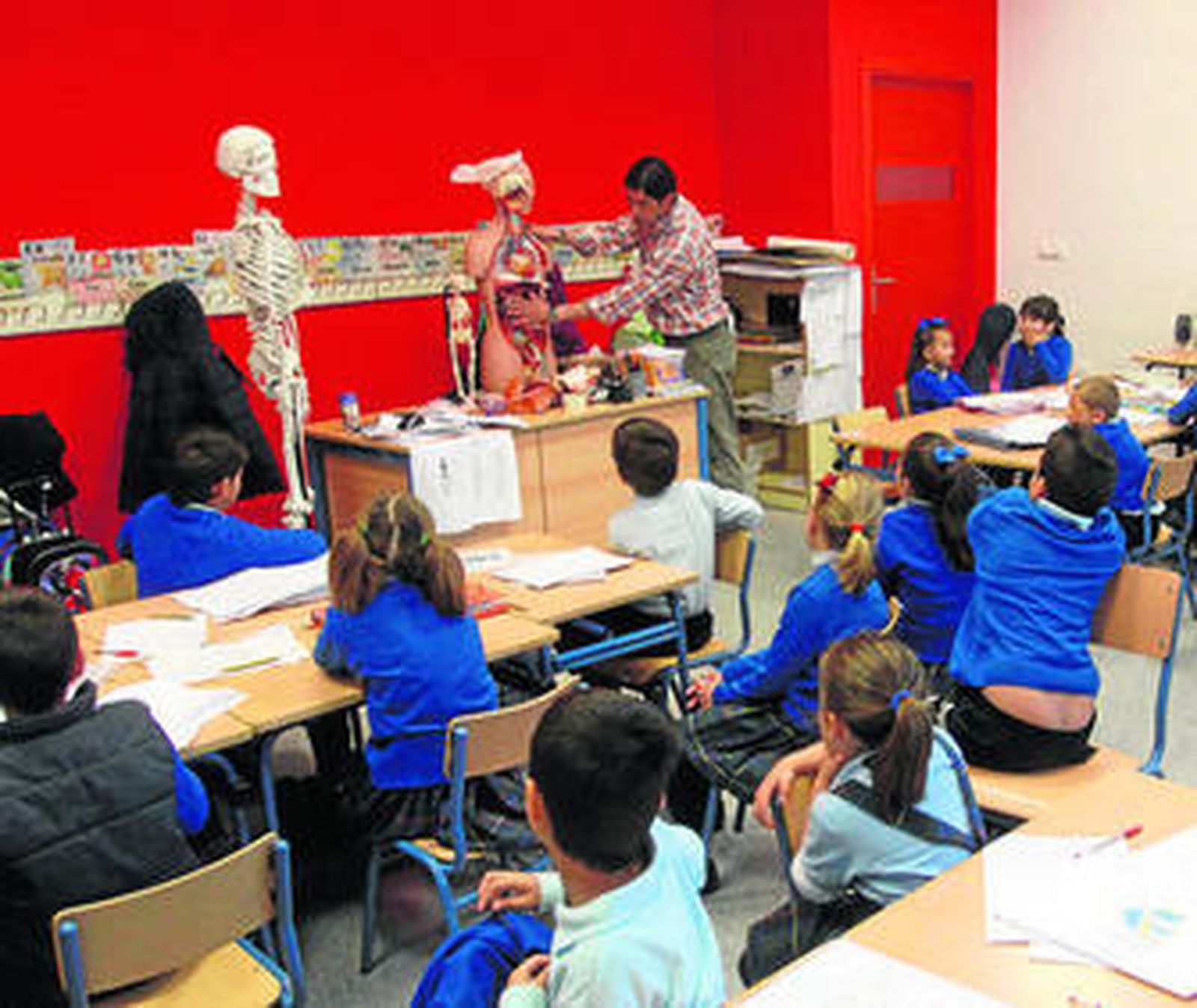 Un maestro imparte su materia en un aula de un colegio.