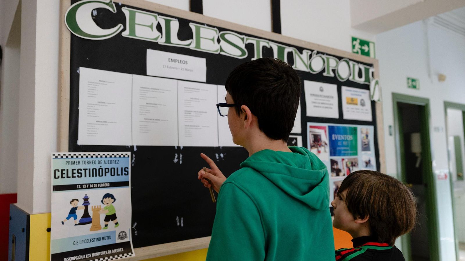 Dos alumnos del centro miran el tablón de anuncios.
