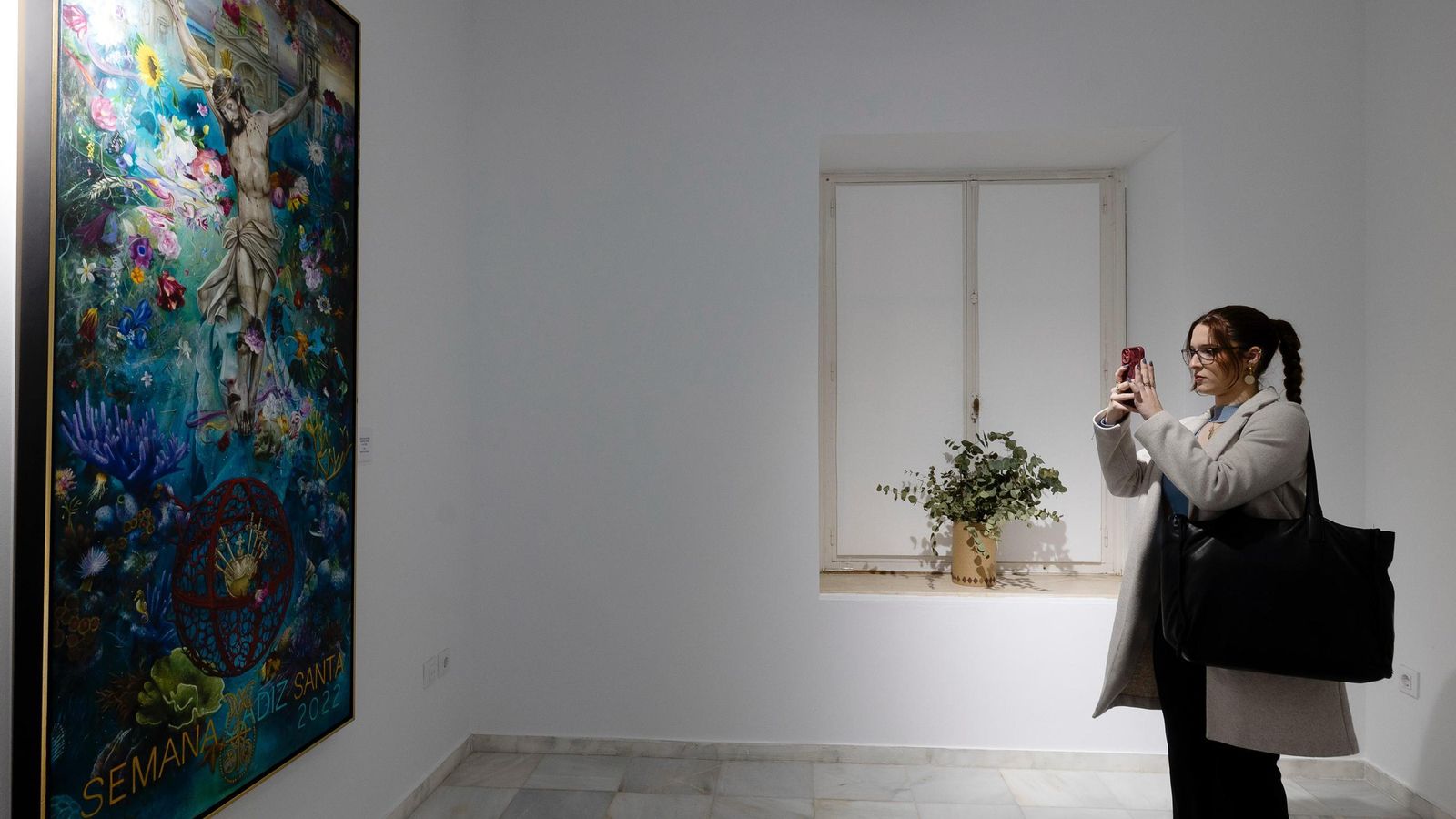 Una joven fotografía el cartel de Antonio Casamitjana en la exposición del centro cultural de la calle Ancha.