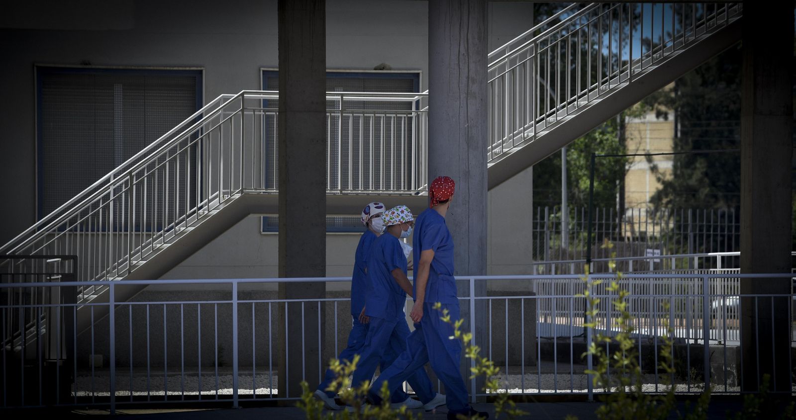 Varios profesionales sanitarios caminan por el entorno hospitalario del Valme.