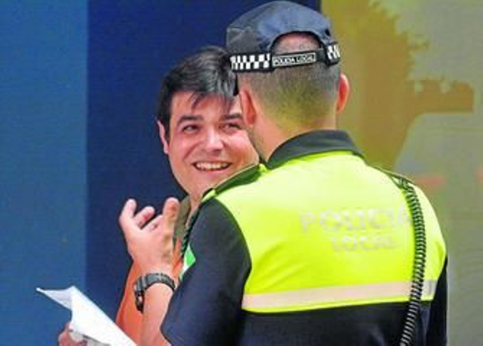 Un policía local atiende a un ciudadano.