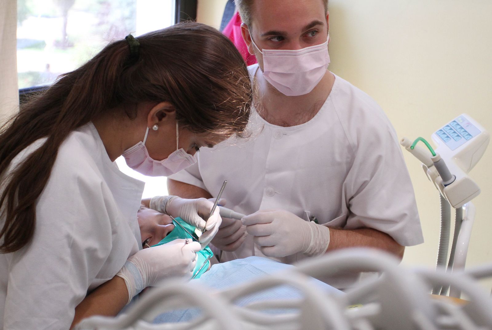 Dos dentistas atienden a un paciente.