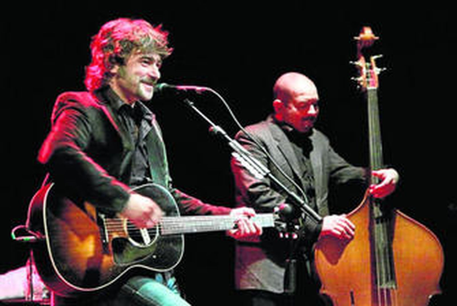 Quique González en primer término con su guitarra,  acompañado de Jacob Reguilón en el Teatro Apolo.