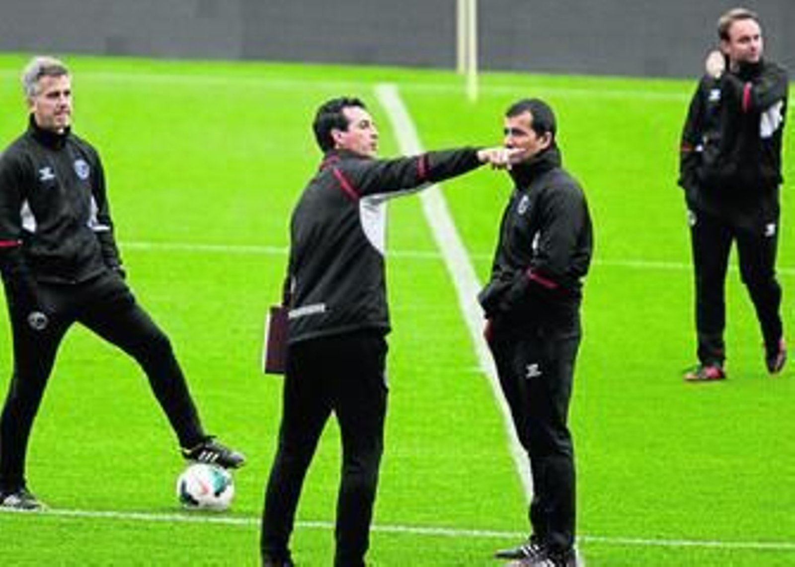 Unai Emery se dirige a su ayudante, Juan Carlos Carcedo, en presencia de los preparadores físicos, Sergio Domínguez y Moisés de Hoyo.