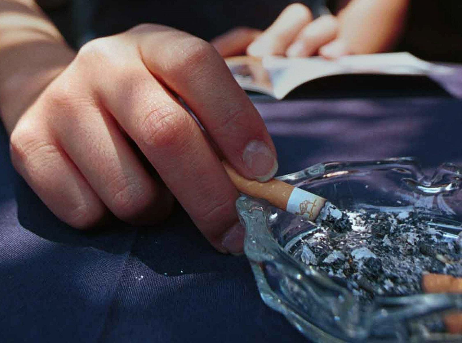 Una persona apura su cigarrillo.