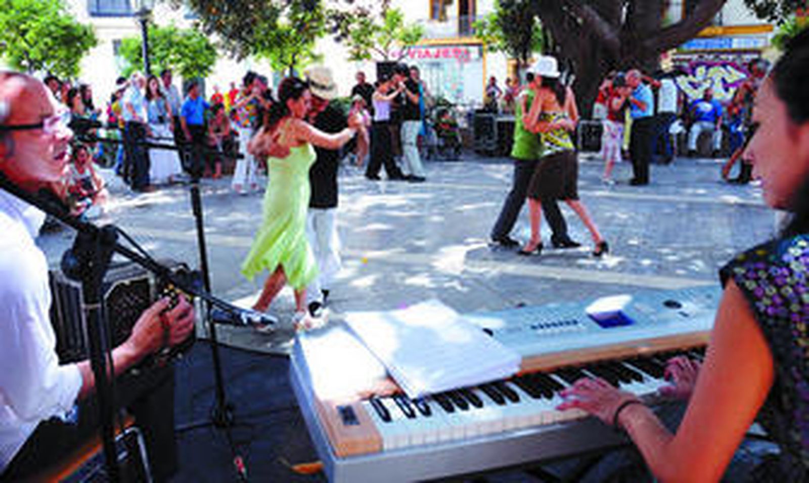 Varias parejas bailan al son de la música del bandoneón, el piano, la guitarra y el contrabajo.
