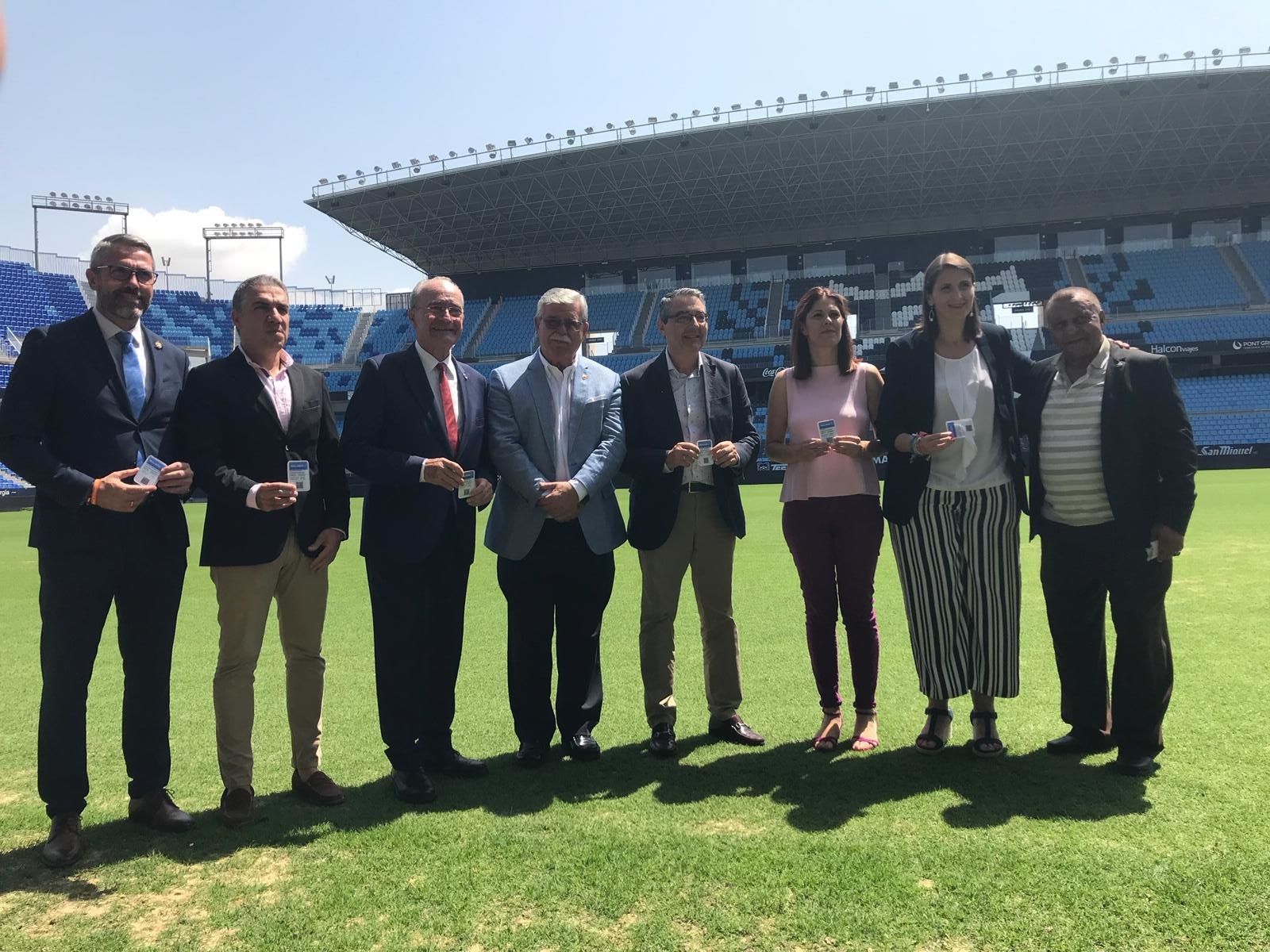 Representantes políticos y del Málaga sobre el césped de La Rosaleda.