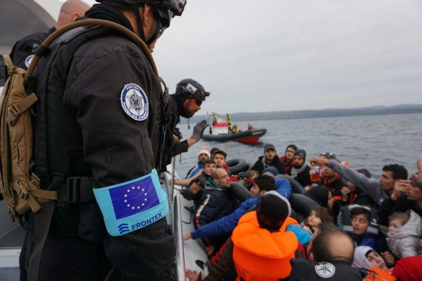 Varios efectivos de Frontex auxilian a un grupo de inmigrantes que navegan en un patera.