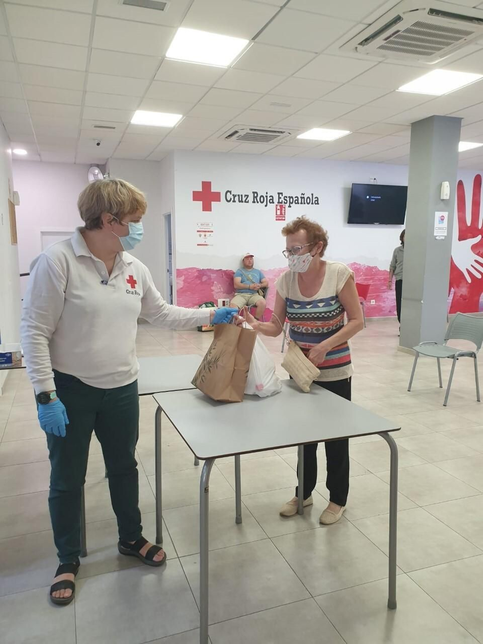 Personas sin recursos recogen de CASA de Cruz Roja su menú de la iniciativa 'Unidos cocinamos para ti¡